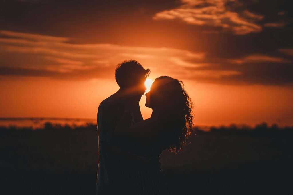 Couple standing close together at sunset in a reflective silhouette, symbolizing emotional tension and hidden relationship dynamics
