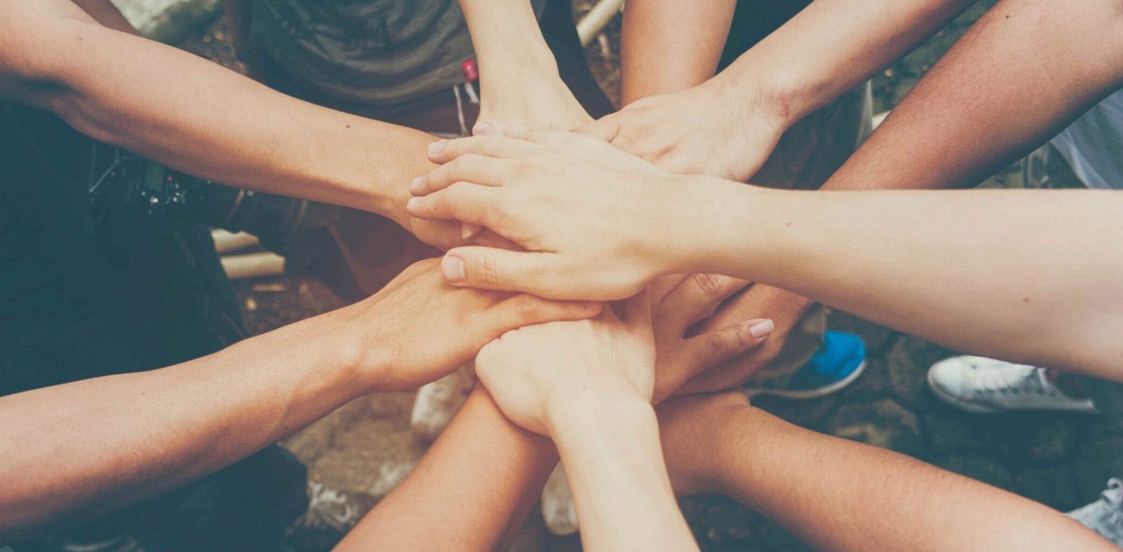 Multiple hands joining together symbolizing trust, unity, and support within the DatingDart community