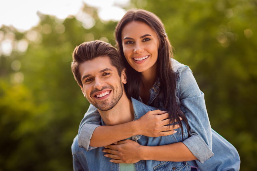 Smiling couple enjoying time outdoors, showing the warmth and emotional closeness found in a healthy marriage.