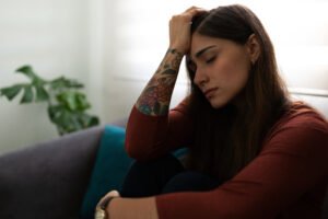 Young woman sitting quietly after a breakup, reflecting on the no contact after breakup decision.