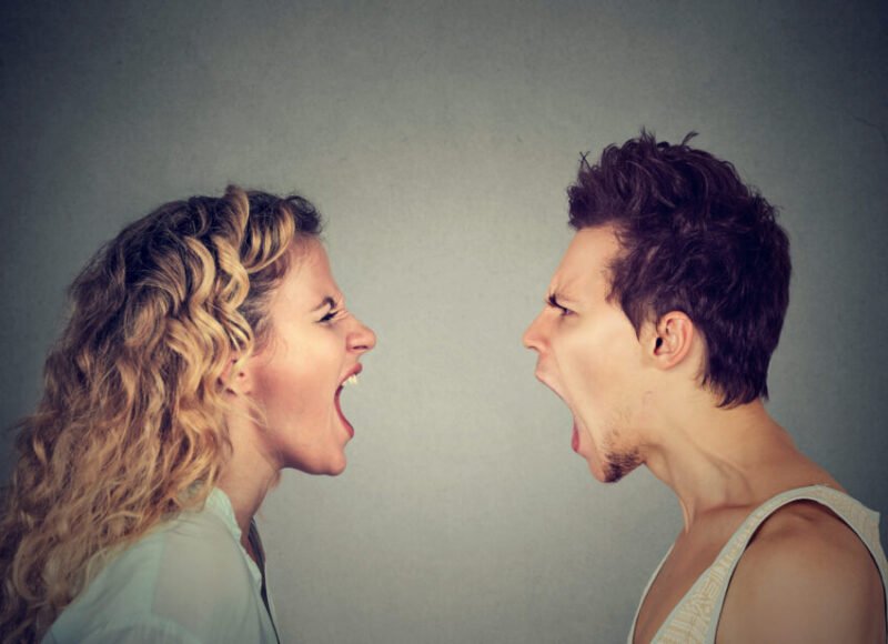 Love conversation turning into an argument between a couple facing each other and shouting