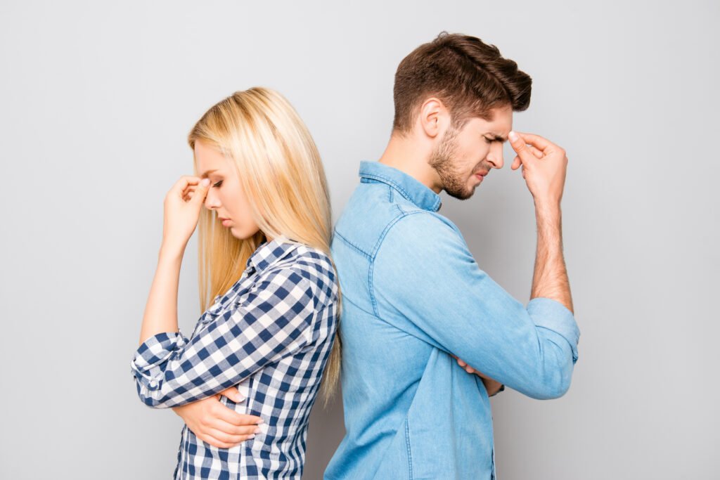 Couple standing back to back looking Emotionally stressed, reflecting growing emotional distance and disconnection in their relationship.