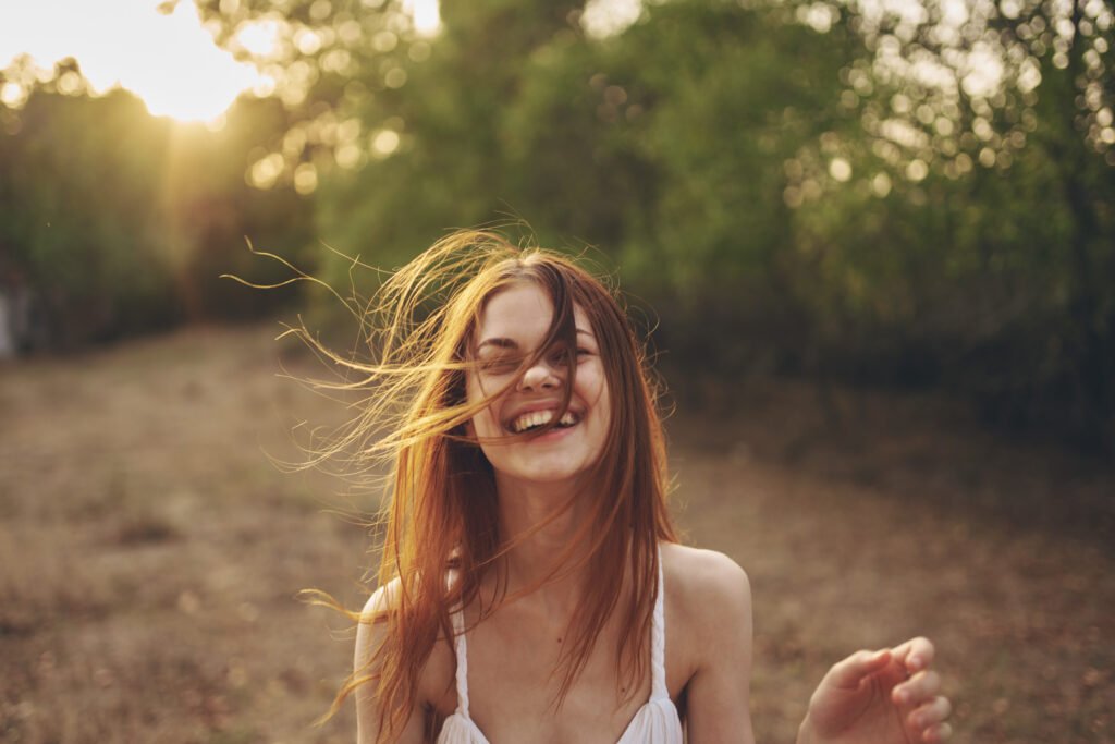 Woman smiling outdoors feeling free and emotionally healed after a breakup