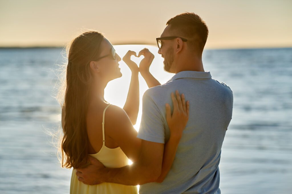 Couple forming a heart shape with their hands in a loving relationship
