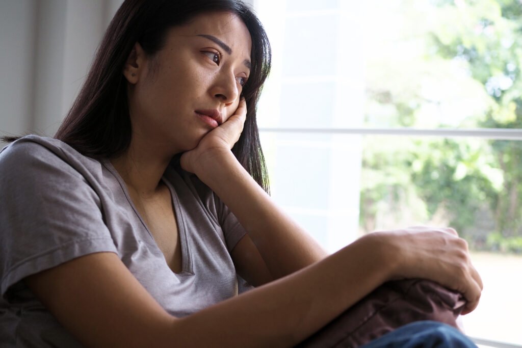 Person sitting quietly and reflecting during emotional stress in a relationship